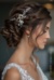 The image shows a woman wearing a white dress and a beautiful bridal hair comb adorned with pearls and crystals. The background is blurred, and there is a watermark on the image.