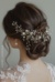 The image shows a woman wearing a white dress and a beautiful bridal hair comb adorned with pearls and crystals. The background is a pristine white, highlighting the intricate details of the hair comb.